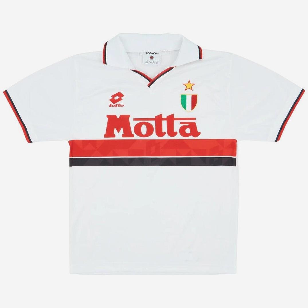 The AC Milan 1993-94 Away Shirt by Retro1999 features a white design with red and black trim, bold Motta sponsor, green-white-red shield badge with gold star—a must-have for fans seeking vintage football style.