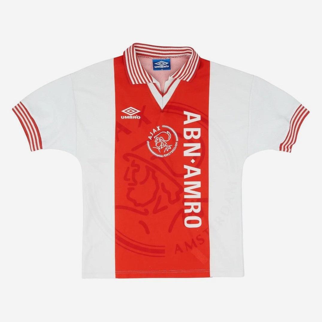 The Retro1999 Ajax 1995-96 Home Shirt has a classic white and red look featuring a bold vertical stripe, ABN AMRO sponsor, Umbro logo, Ajax crest, and iconic red and white collar and sleeves—a true football classic.