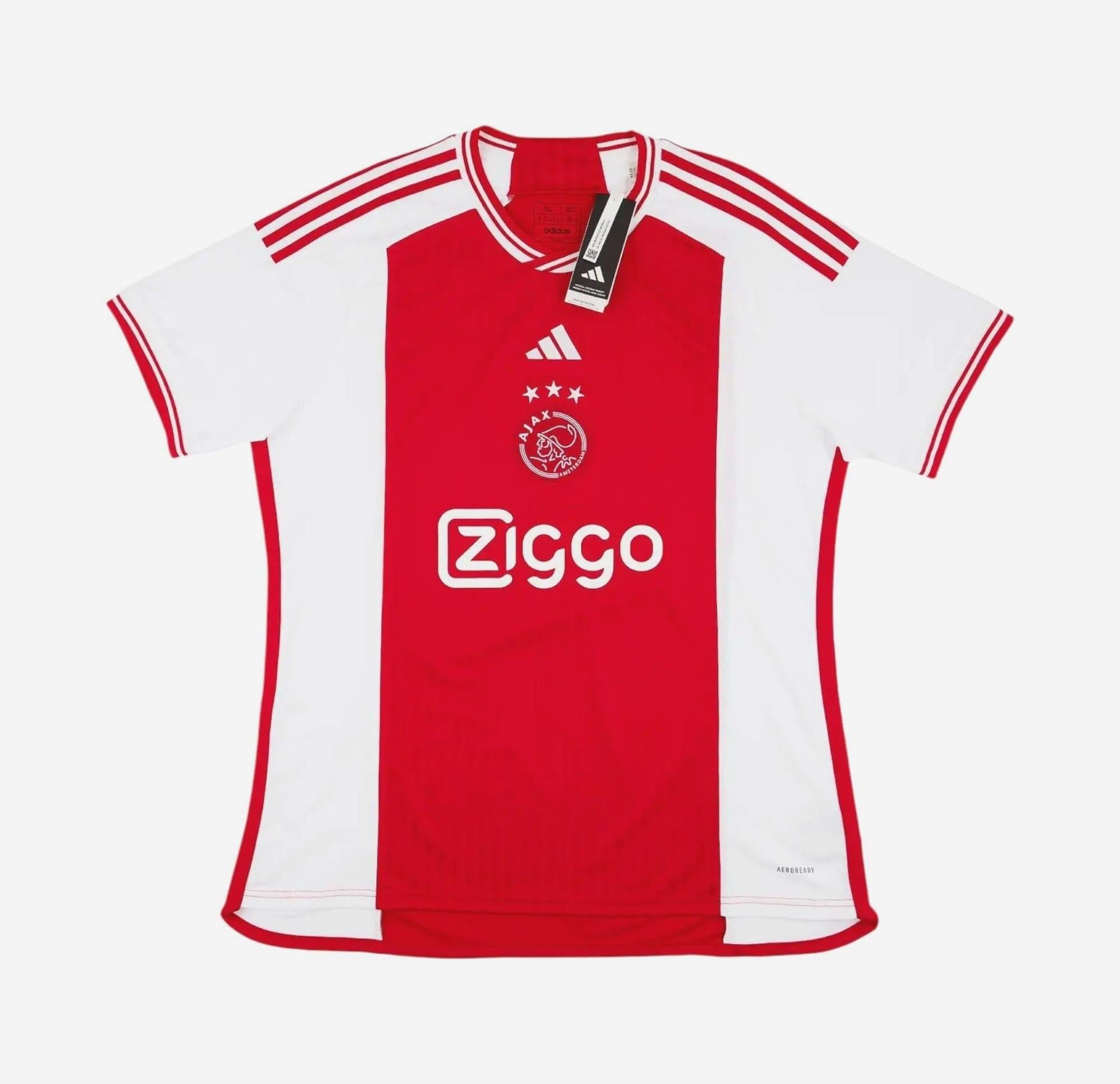 The Retro1999 Ajax 2023-24 Home Shirt features classic red and white colors, three stars above the crest, Ziggo sponsor, Adidas details, red shoulder stripes, and a collar tag—ideal for fans of this iconic kit.
