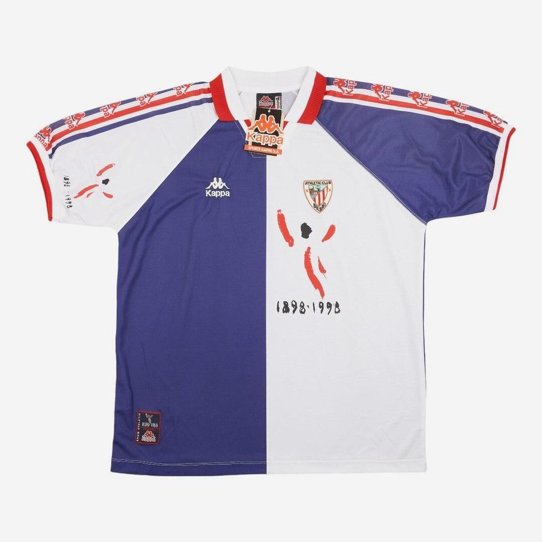 The Athletic Bilbao 1995-97 Away Shirt by Retro1999 features a blue and white half-and-half design, red brushstroke accents, club crest, and 1898-1998 text—perfect for football collectors and La Liga fans.