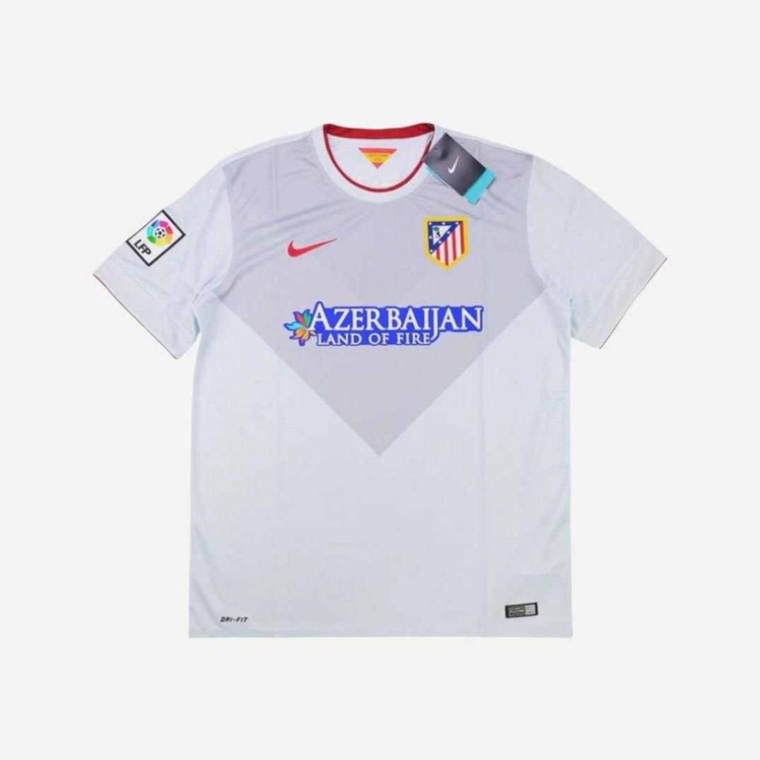 The Retro1999 Atletico Madrid 2014-15 Away Shirt features white and light grey colors, a red Nike logo, club crest, Azerbaijan Land of Fire sponsor, and La Liga sleeve patch, shown on a plain white background.