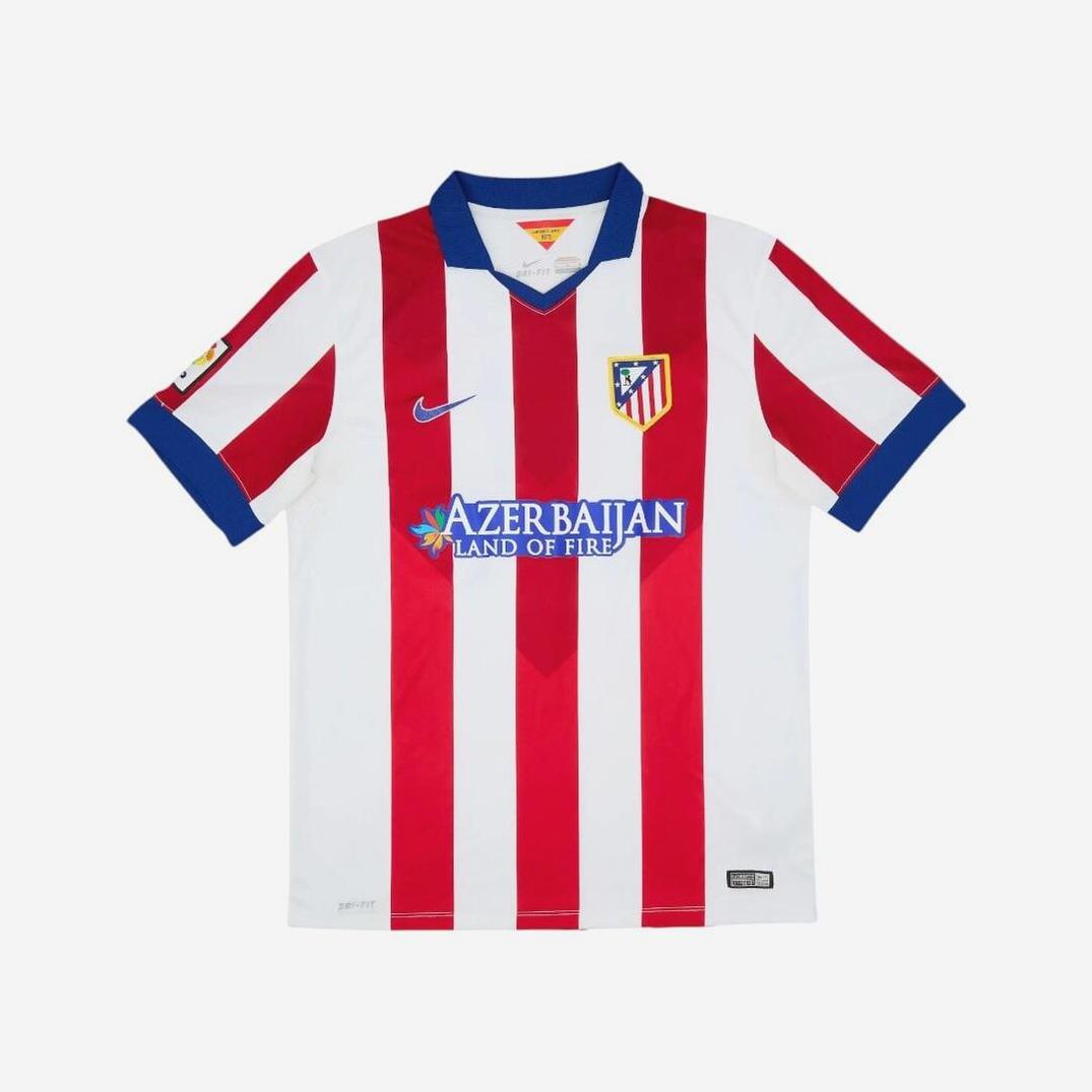 The Atletico Madrid 2014-15 Home Shirt by Retro1999 features iconic red and white stripes, blue collar and cuffs, club crest, Nike logo, and Azerbaijan Land of Fire sponsor—a true La Liga classic.