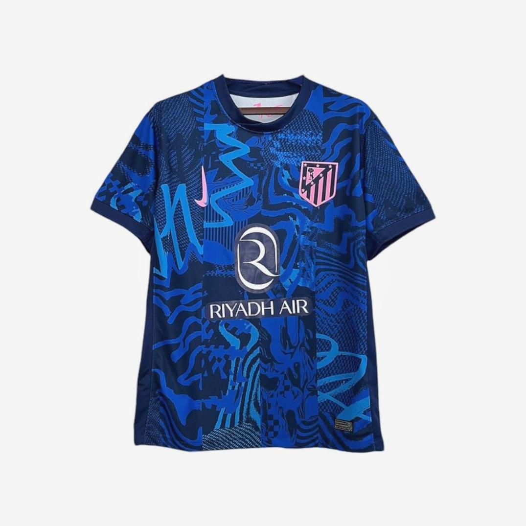 The Retro1999 Atletico Madrid 2024-25 Third Shirt features a blue base with abstract patterns, pink accents, the club crest, and Riyadh Air sponsor—a stylish retro-inspired kit for the La Liga season.