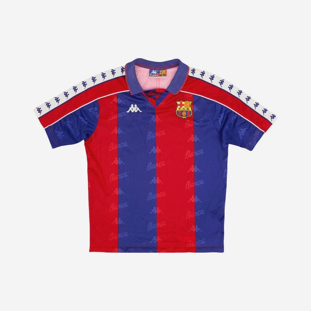 The Barcelona 1992-95 Home Shirt by Retro1999 features classic red and blue stripes, Kappa logos on the chest and sleeves, and the FC Barcelona crest—a timeless retro kit for football fans.