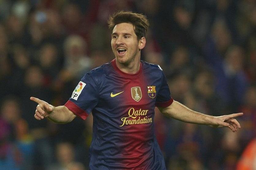 A soccer player in a Retro1999 Barcelona 2012-13 Home Shirt celebrates with arms outstretched and a smile on the field during a La Liga victory.