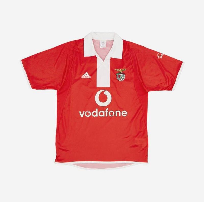 The Retro1999 Benfica 2004-05 Home Shirt has a red retro design with white collar and sleeve details, club crest, Adidas logo, and Vodafone sponsor—an iconic shirt from their title-winning season. Displayed on a plain white background.