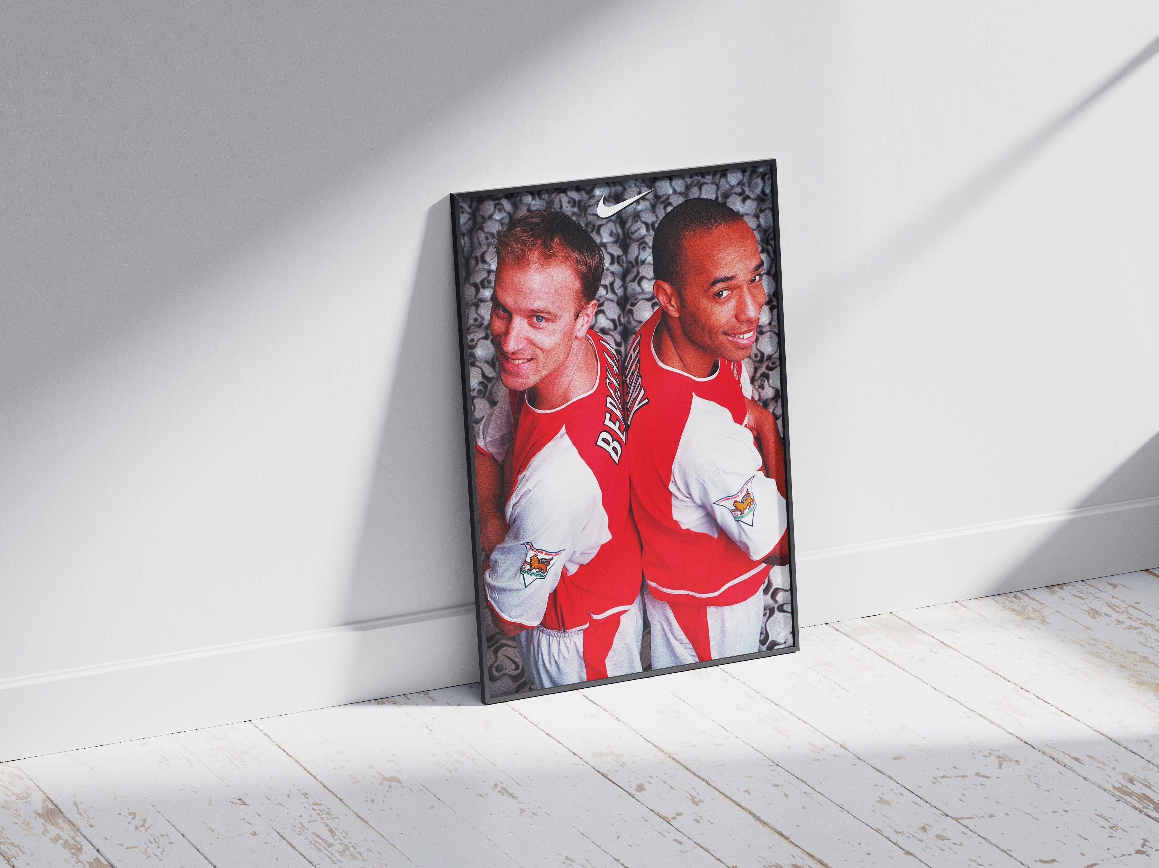 The Bergkamp x Henry Poster by Retro1999 features two football legends in red and white, standing back-to-back—perfect as striking sports decor or unique memorabilia for any soccer enthusiasts collection.