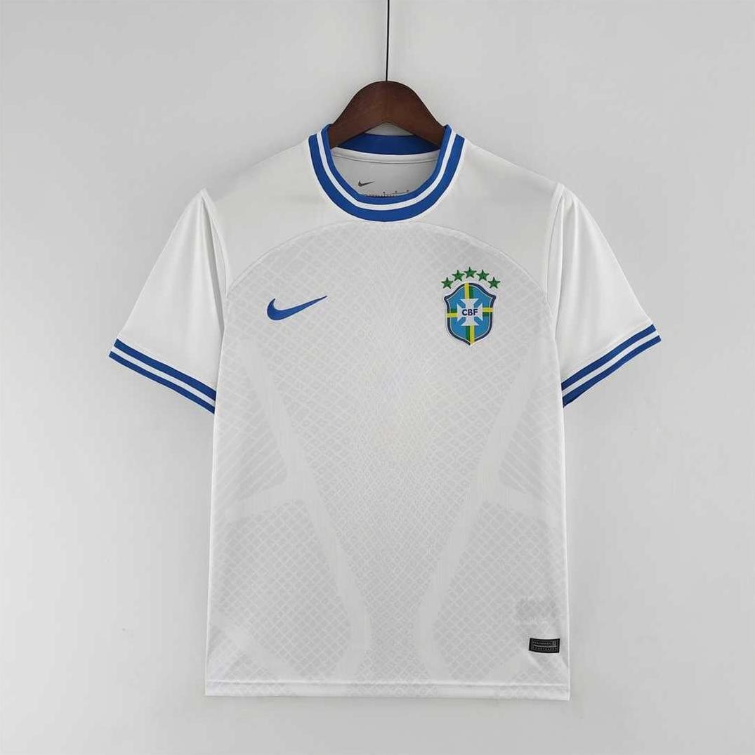 The Brazil 2022 Away Shirt Special by Retro1999 features a classic white design with blue collar and sleeve accents, Nike logo, and Brazil crest with five stars, displayed on a wooden hanger against a plain background.