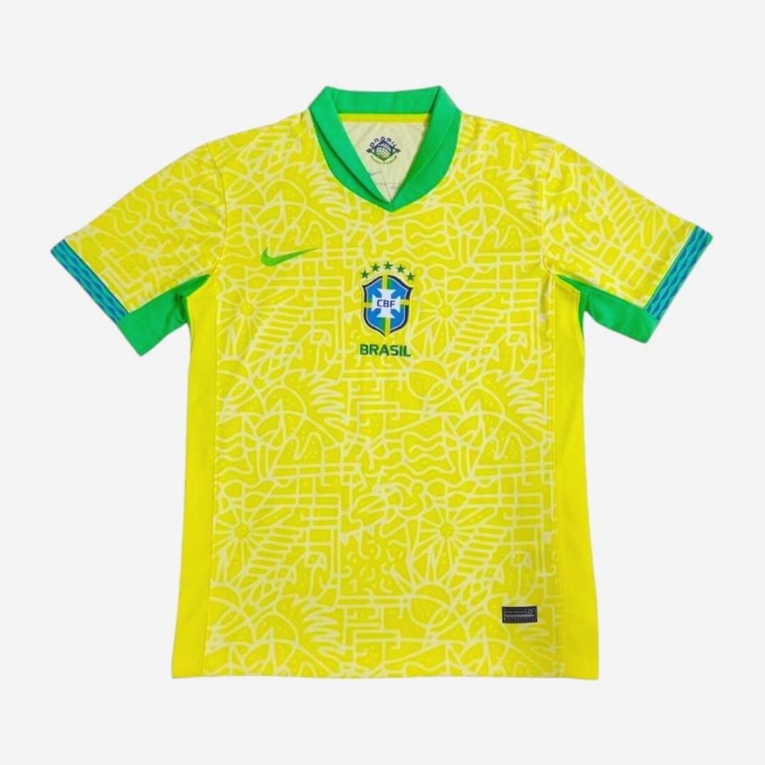 The Brazil 2024 Home Shirt by Retro1999 is a yellow kit for the national team with a green collar, blue sleeve accents, a blue Nike logo, and the classic five-star crest, featuring a subtle abstract pattern for modern retro style.