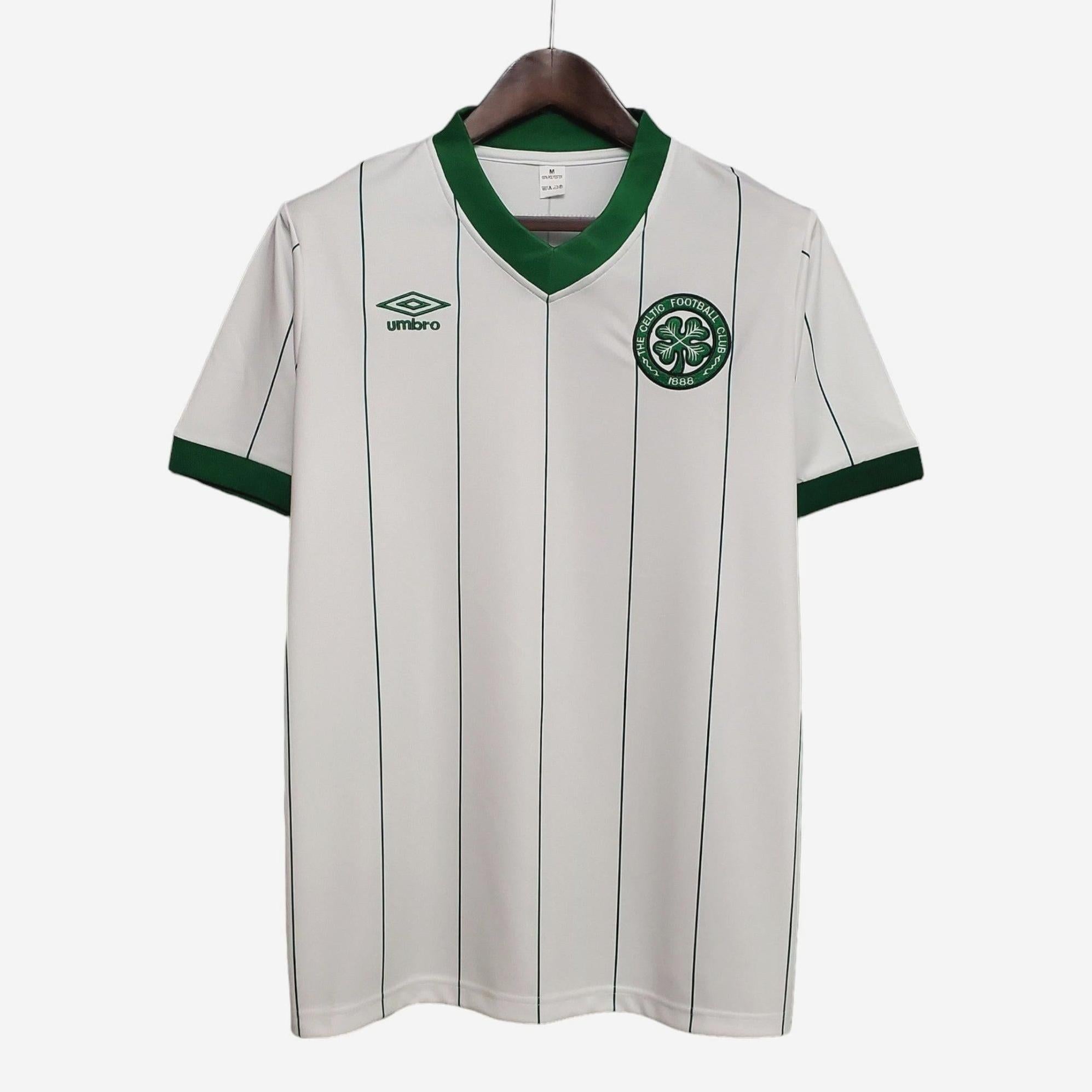 The Retro1999 Celtic 1984-86 Away Shirt features a white design with thin green stripes, green cuffs, and a V-neck collar. This Authentic piece from the Retro Collection is displayed on a hanger.