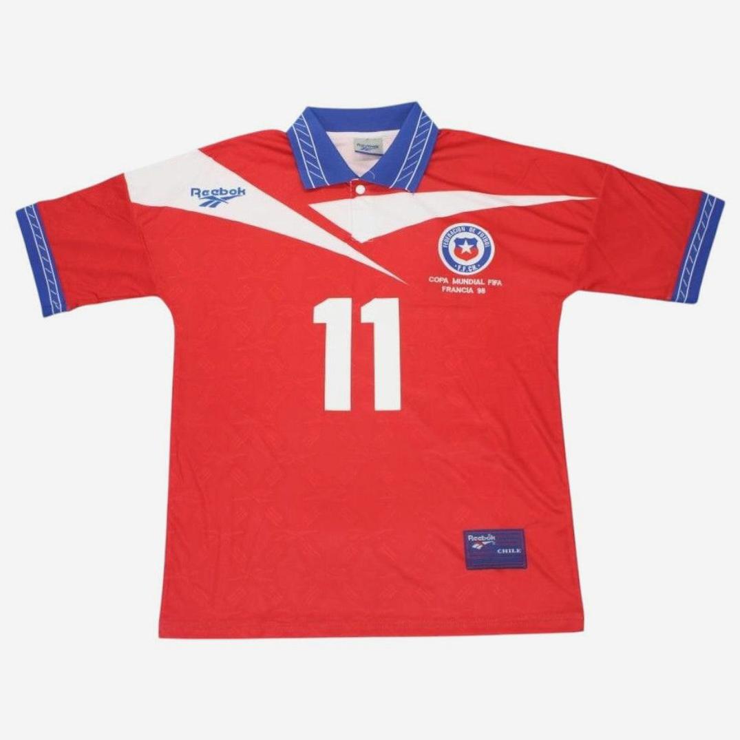 The Chile 1998 Home Shirt by Retro1999 features a blue and white collar and cuffs, number 11 on the front, Reebok logo, and Copa Mundial FIFA Francia 98 badge—a perfect retro kit for classic Chilean football fans.