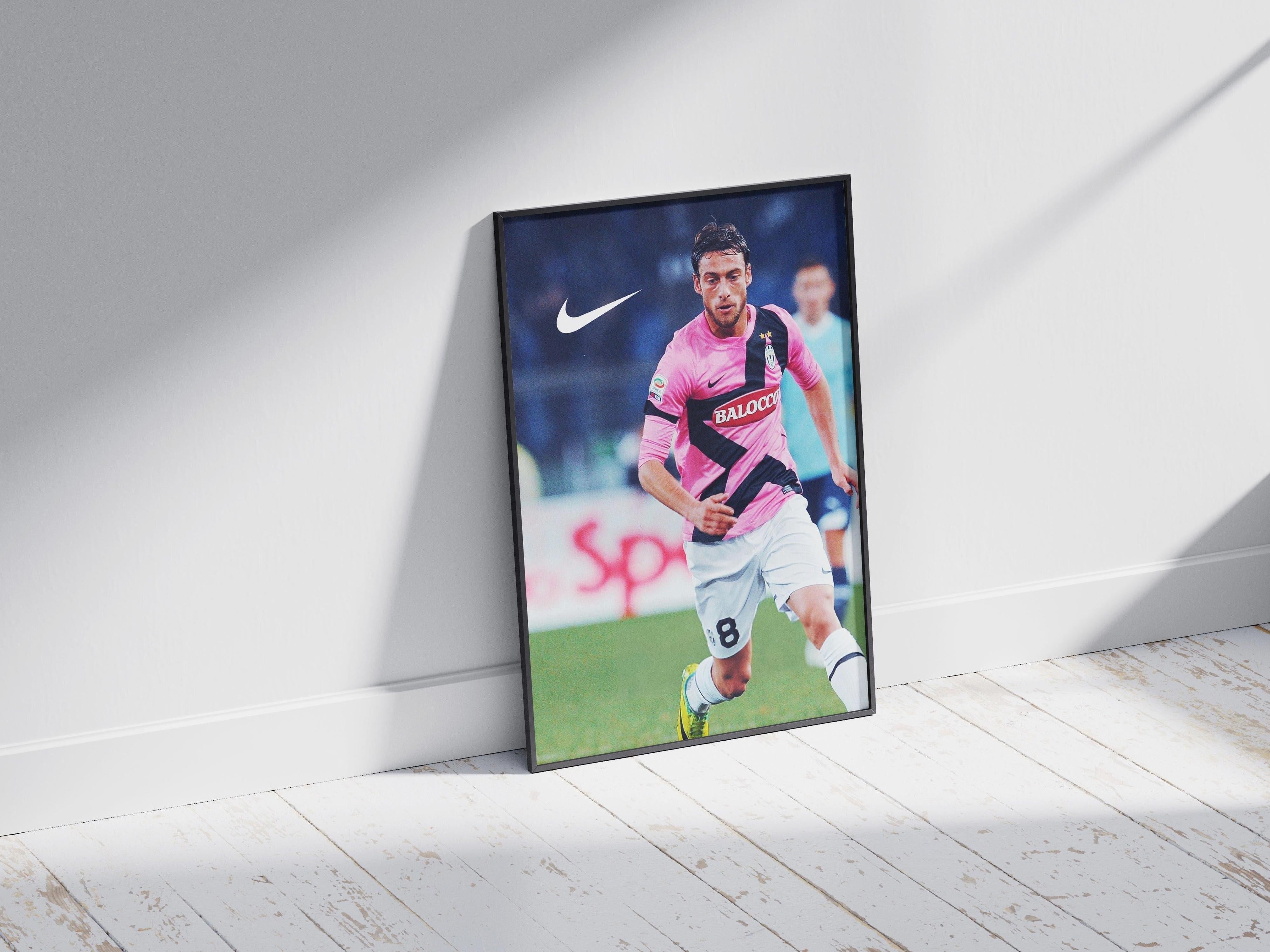 The Retro1999 Claudio Marchisio x Juventus 2011/12 Poster shows Marchisio in a pink and black jersey, running on the field—a must-have print for every Serie A memorabilia collection.