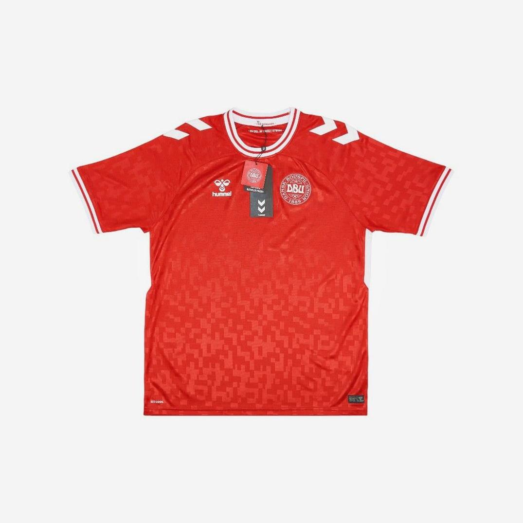 The Retro1999 Denmark 2024 Home Shirt is a red short-sleeved soccer jersey with white accents, iconic shoulder chevrons, and chest crests. Tags are attached to the collar—a classic tribute to football heritage.