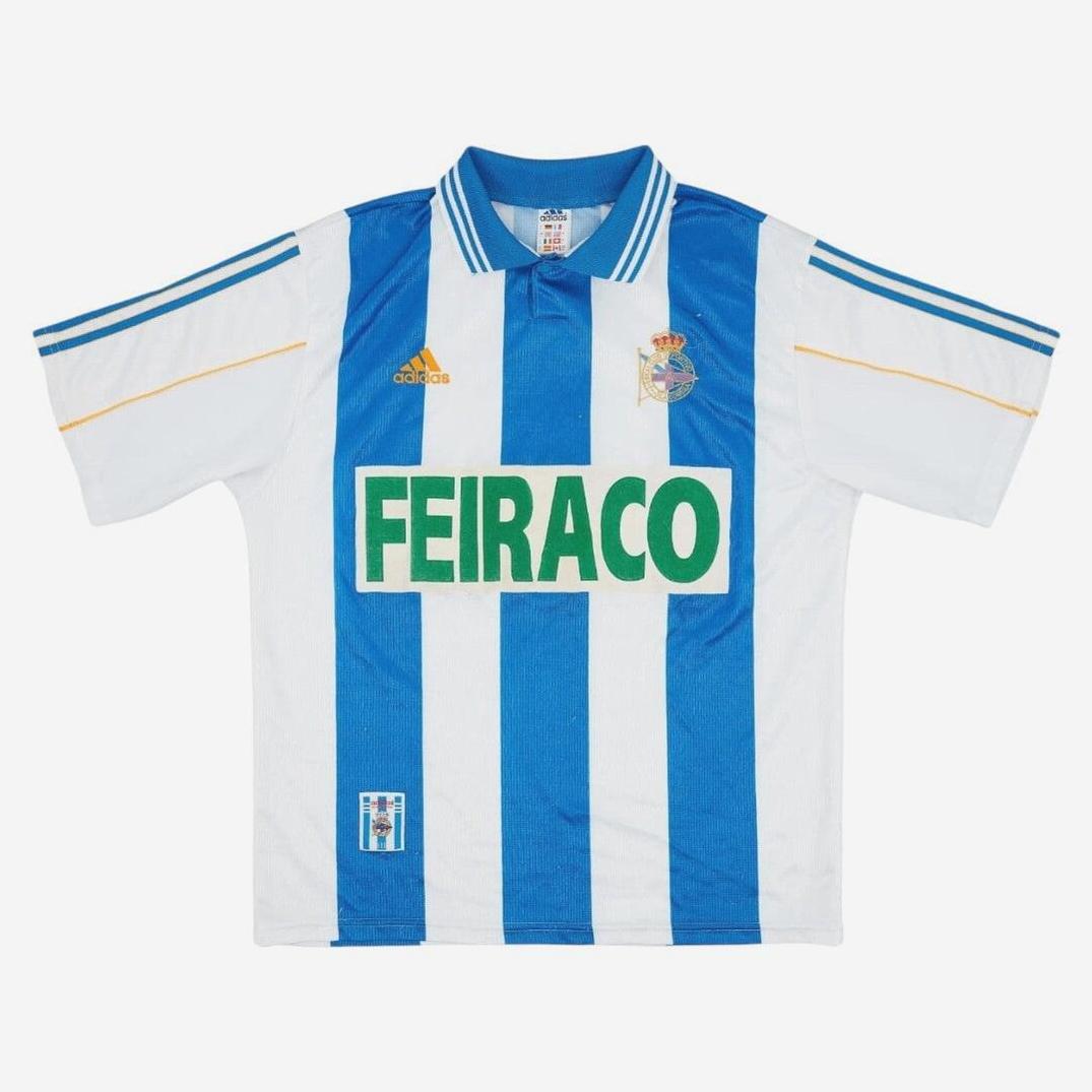 The Deportivo 1999-00 Home Shirt by Retro1999 features blue and white vertical stripes, green FEIRACO sponsor, Deportivo La Coruña crest, Adidas logo, and a blue collar with yellow-trimmed sleeves—classic retro style.