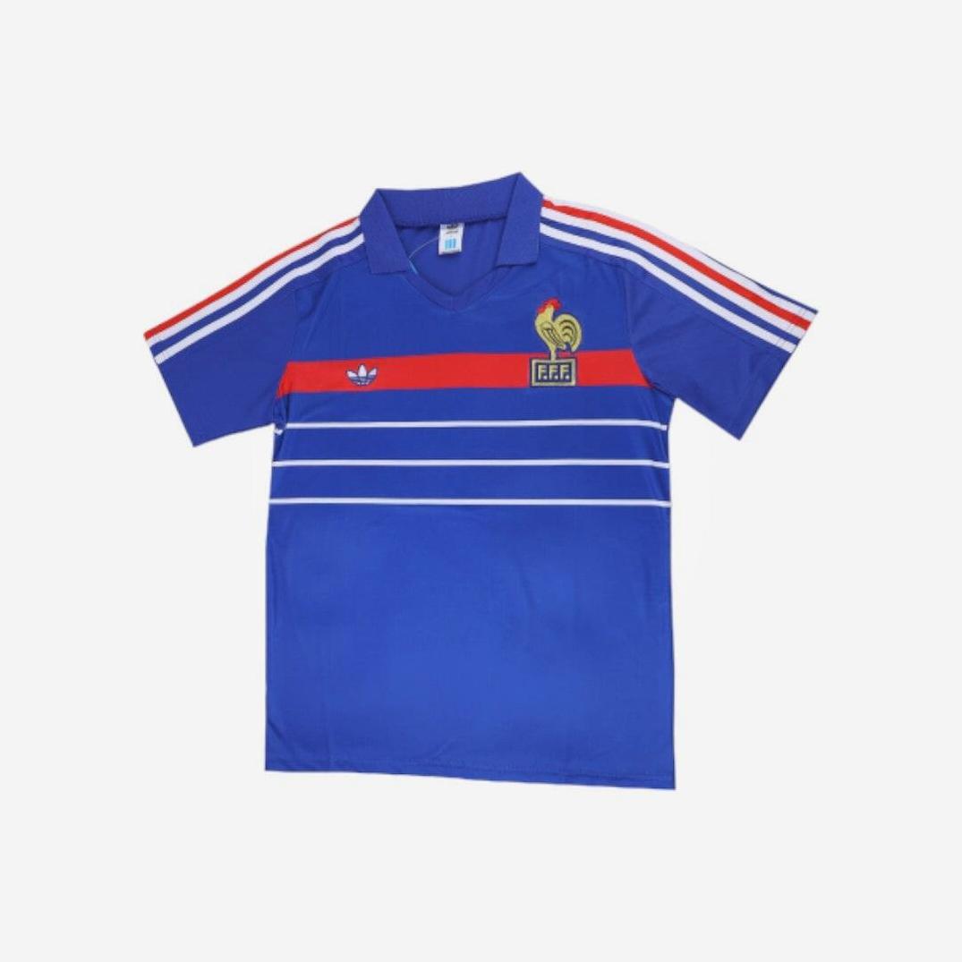 Retro1999 France 1984 Home Shirt: blue short-sleeve jersey with white and red chest and shoulder stripes, inspired by the iconic original and featuring the French Football Federation (FFF) crest on the left chest.