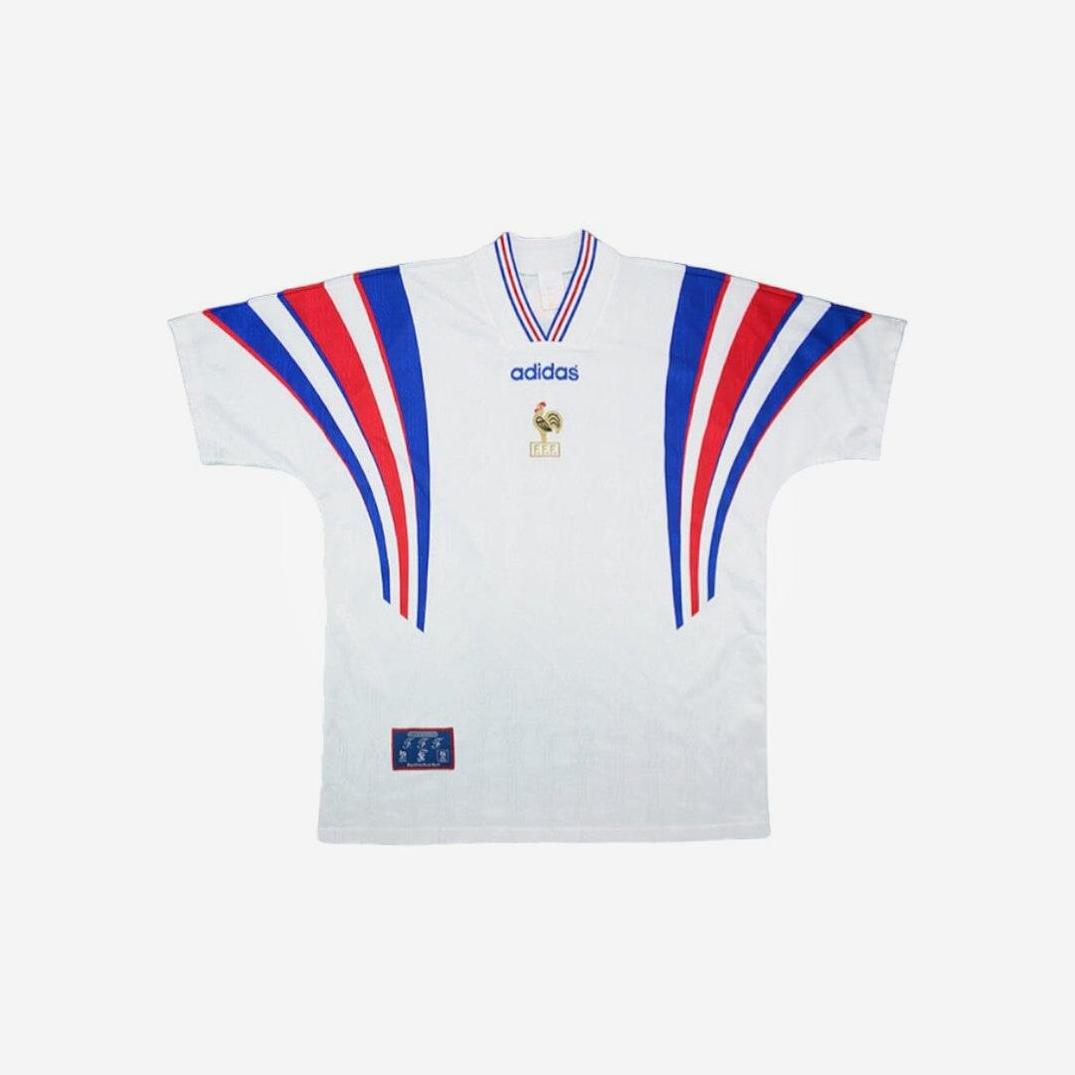 The Retro1999 France 1996 Away Shirt is a white jersey with blue and red curved stripes on the shoulders and sleeves, a gold FIFA emblem at the center, and a v-neck collar—a true classic retro football kit.