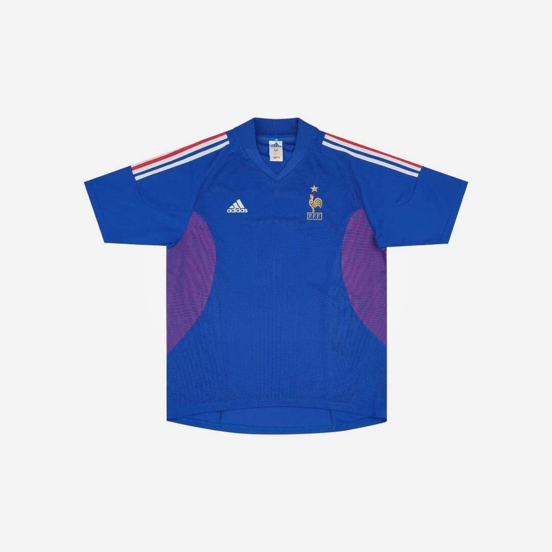 Retro1999 France 2002 Home Shirt in blue, with red and white shoulder stripes, a gold star above the France crest, and purple side panels—an iconic retro kit photographed on a plain white background.