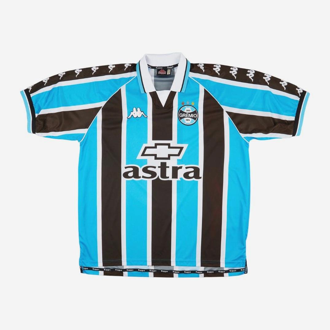 The Retro1999 Grêmio 1999-00 Home Shirt features blue, black, and white vertical stripes, a white collar, and classic sponsor logos—famously worn by Ronaldinho Gaúcho—displayed flat on a white background.