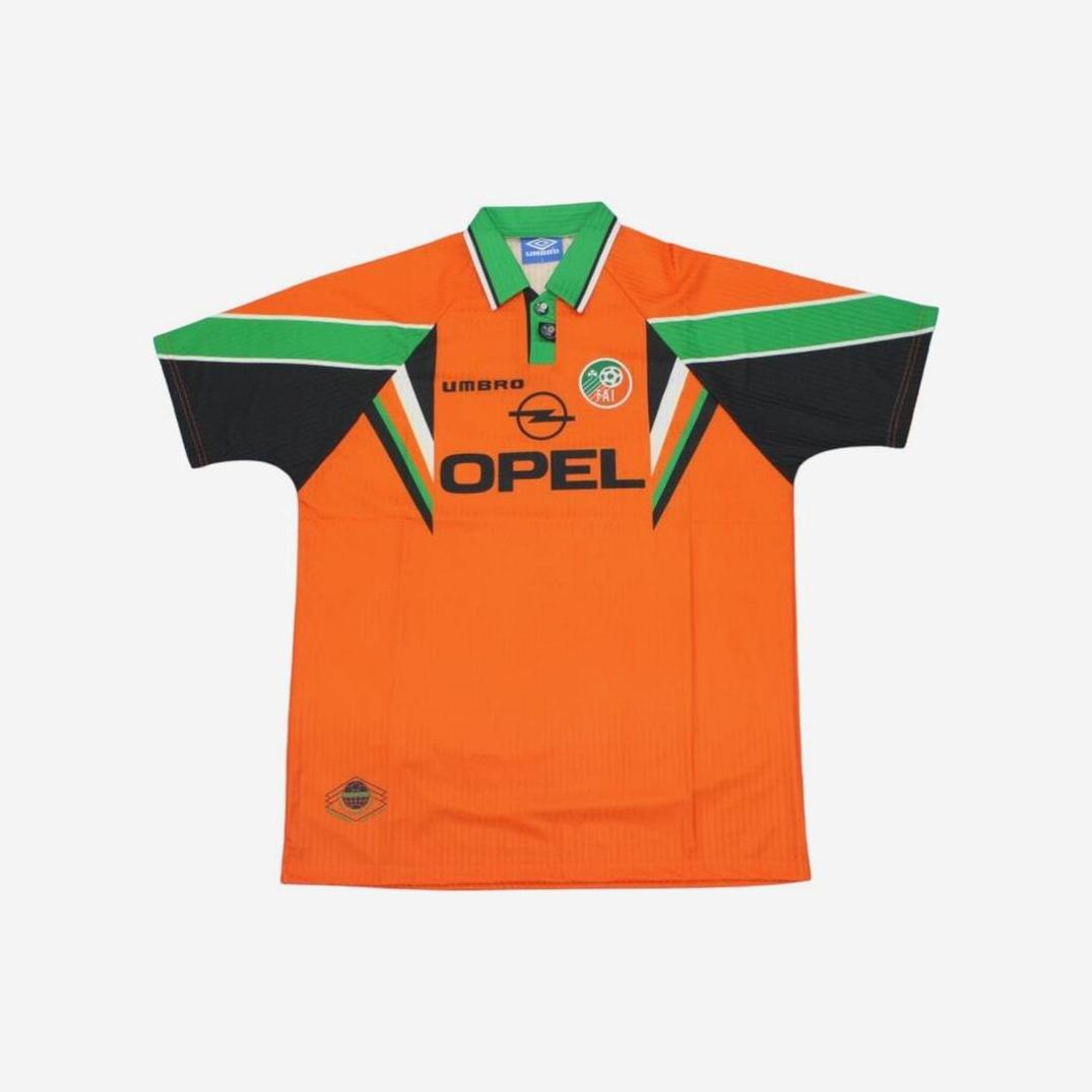 The Retro1999 Ireland 1997/98 Away Shirt is orange with green and black details, featuring a green collar, Opel sponsor logo, team crest on the chest, and classic black, green, and orange sleeve accents.