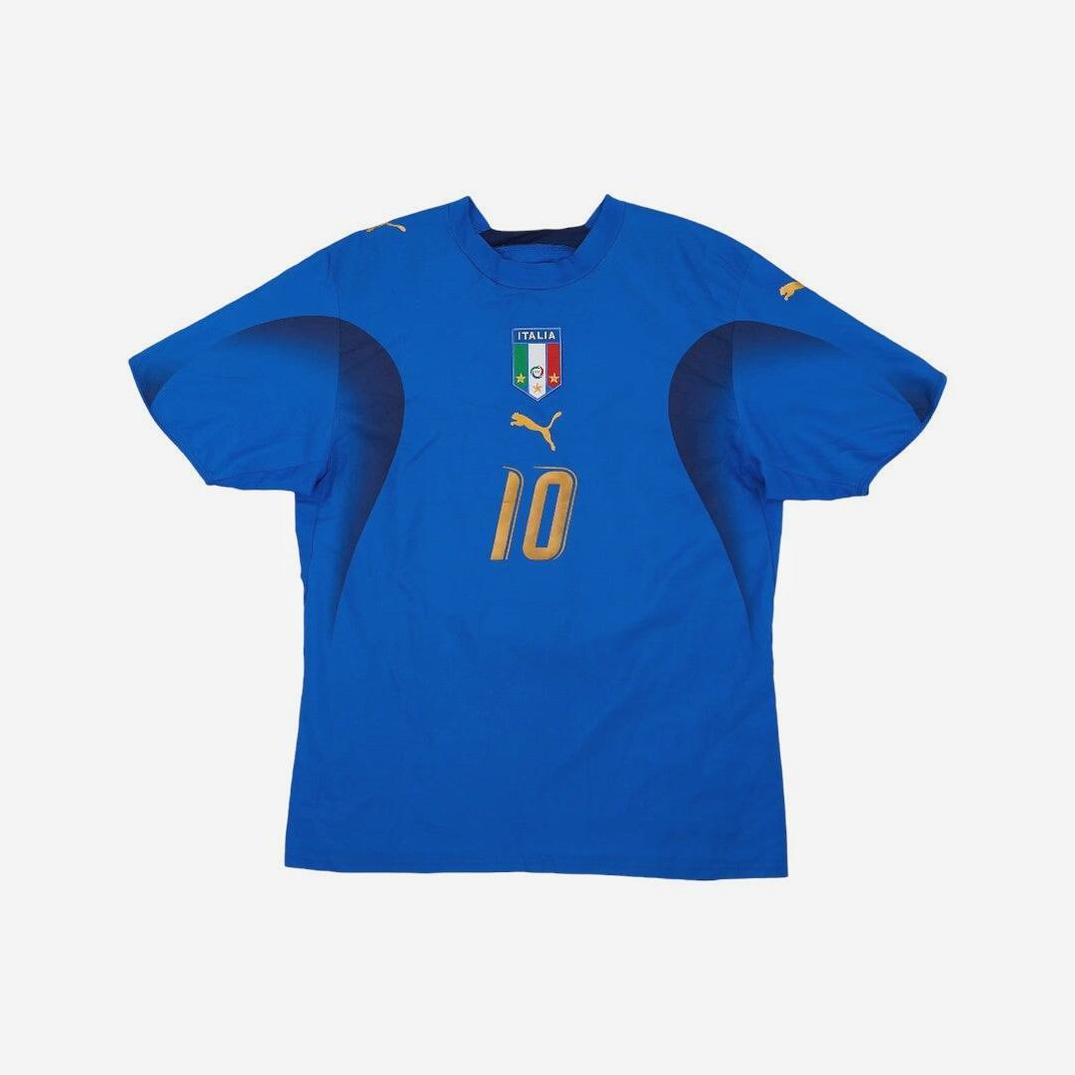 The Retro1999 Italy 2006 Home Shirt features number 10 in gold, a Puma logo, and Italian crest on the chest, showcasing authentic retro design and football heritage against a plain white background.