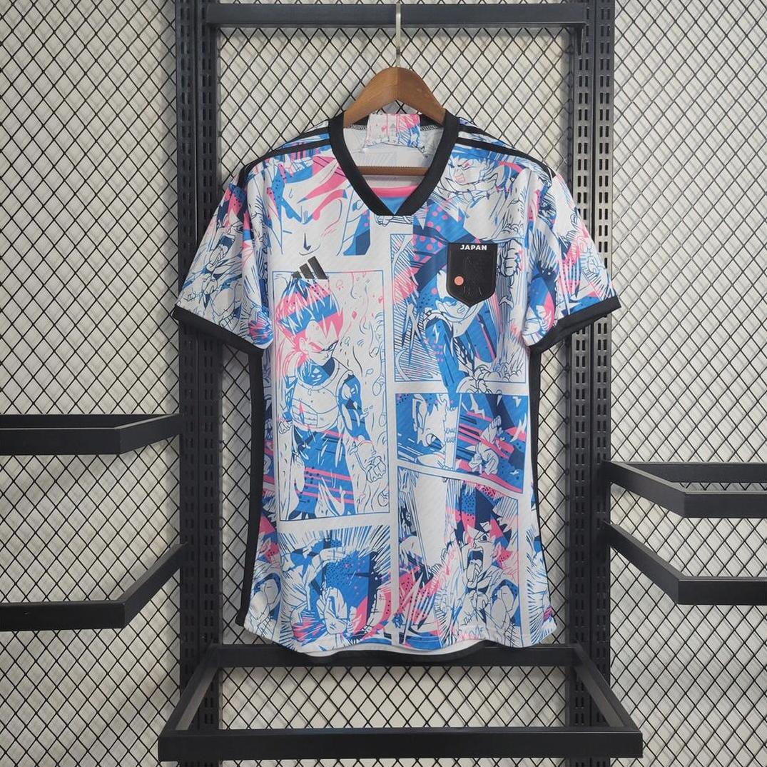 The Retro1999 Japan 2022 Anime Shirt, a short-sleeved jersey with black trim and a blue-pink manga comic print, features a Japan chest patch and hangs on a wooden hanger against a metal grid wall.