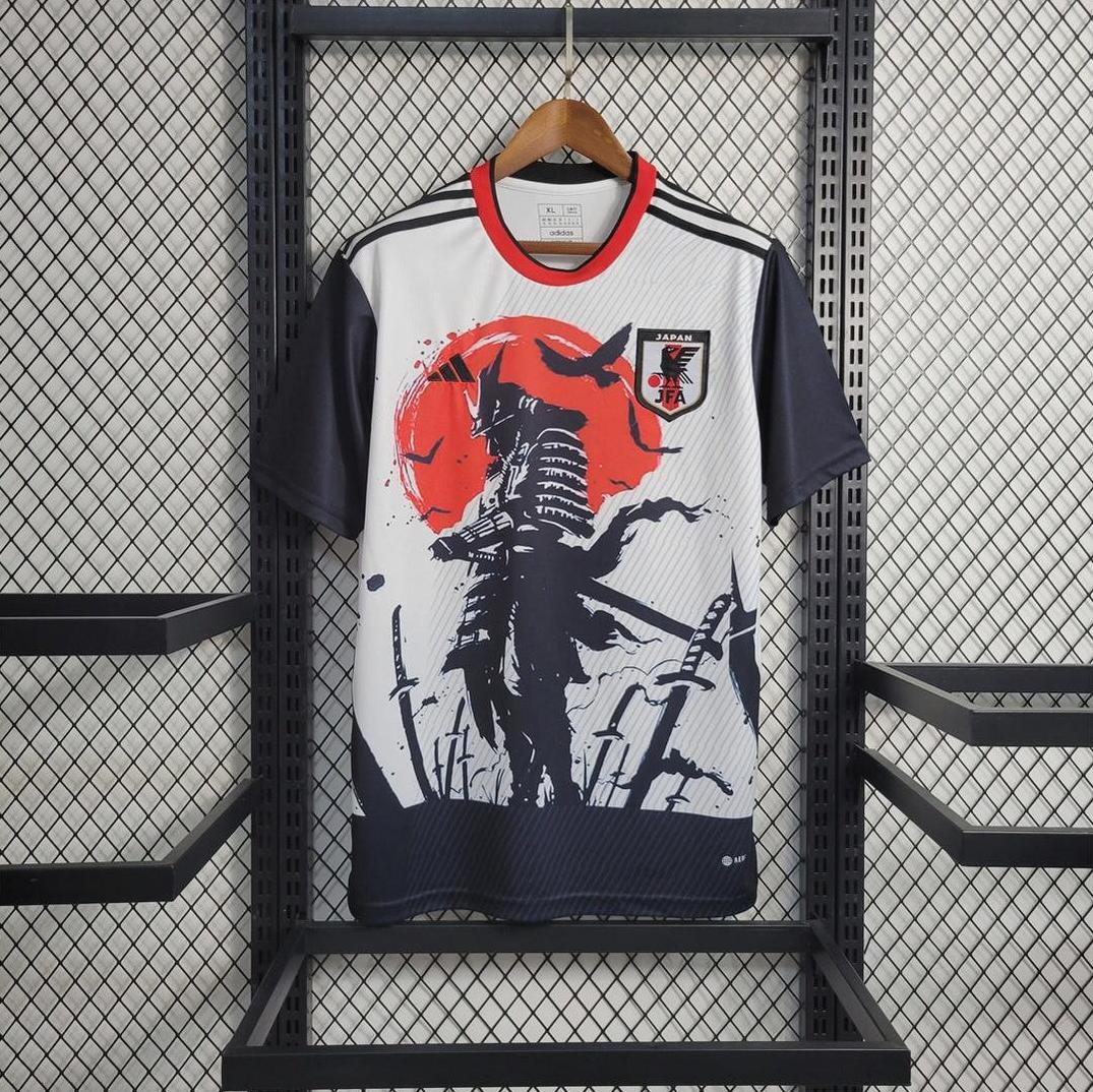 The Retro1999 Japan 2023 Samurai Special Edition jersey, with a samurai graphic, red sun, black-and-white design, and national team logo, hangs on display—a standout piece for fans of unique sports apparel.