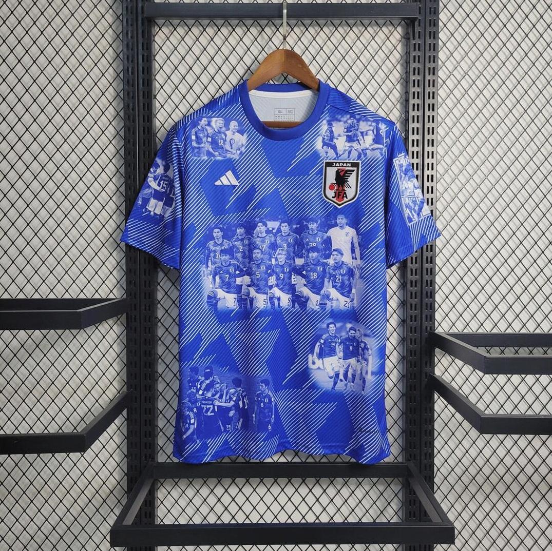 The Retro1999 Japan 2023 Special Edition jersey, featuring white geometric patterns and black-and-white team photos inspired by a retro kit, hangs on a wooden hanger against a metal mesh backdrop, showcasing national pride.
