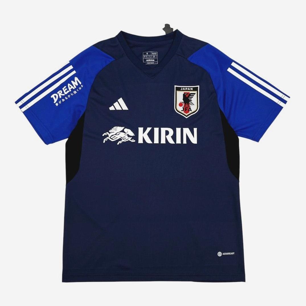 The Japan 2024-25 Pre-Match Shirt by Retro1999 features a dark blue design with white sleeve stripes—ideal for national team fans wanting retro style.