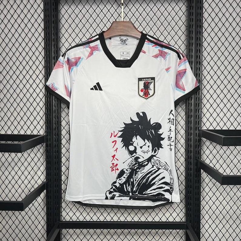 The Retro1999 Japan 2024 Special Edition Shirt is white with red, blue, and gray shoulder patterns, features Monkey D. Luffy from One Piece and Japanese text, and is displayed on a hanger against a mesh wall.