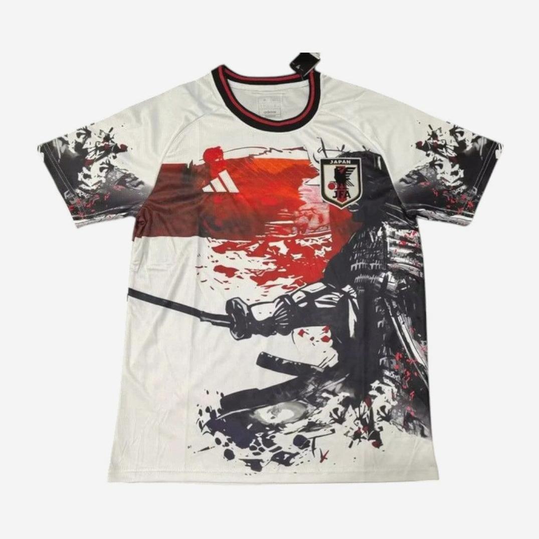 The Retro1999 Japan 2025-26 Special Edition Shirt is a white premium fabric top with a red sun, black-and-white samurai and sword, Japans football crest, and splattered paint—capturing the bold spirit of retro football kits.