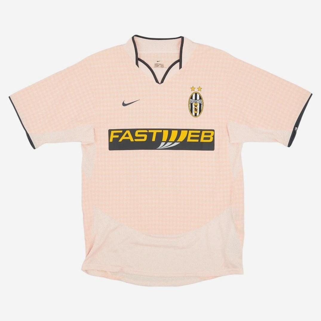 A pale pink Juventus 2003-04 Away Shirt by Retro1999 features black trim, Nike logo, club crest with two stars, and FASTWEB sponsor in black and yellow, capturing Italian football heritage on a white background.