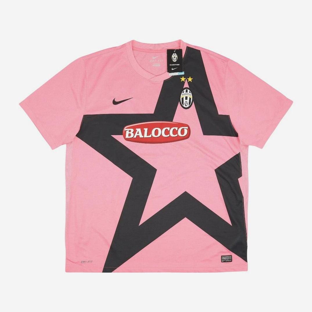 The Retro1999 Juventus 2011-12 Away Shirt is a pink jersey with a large black star, club crest with two stars for Serie A wins, and bold sponsor logos across the chest.