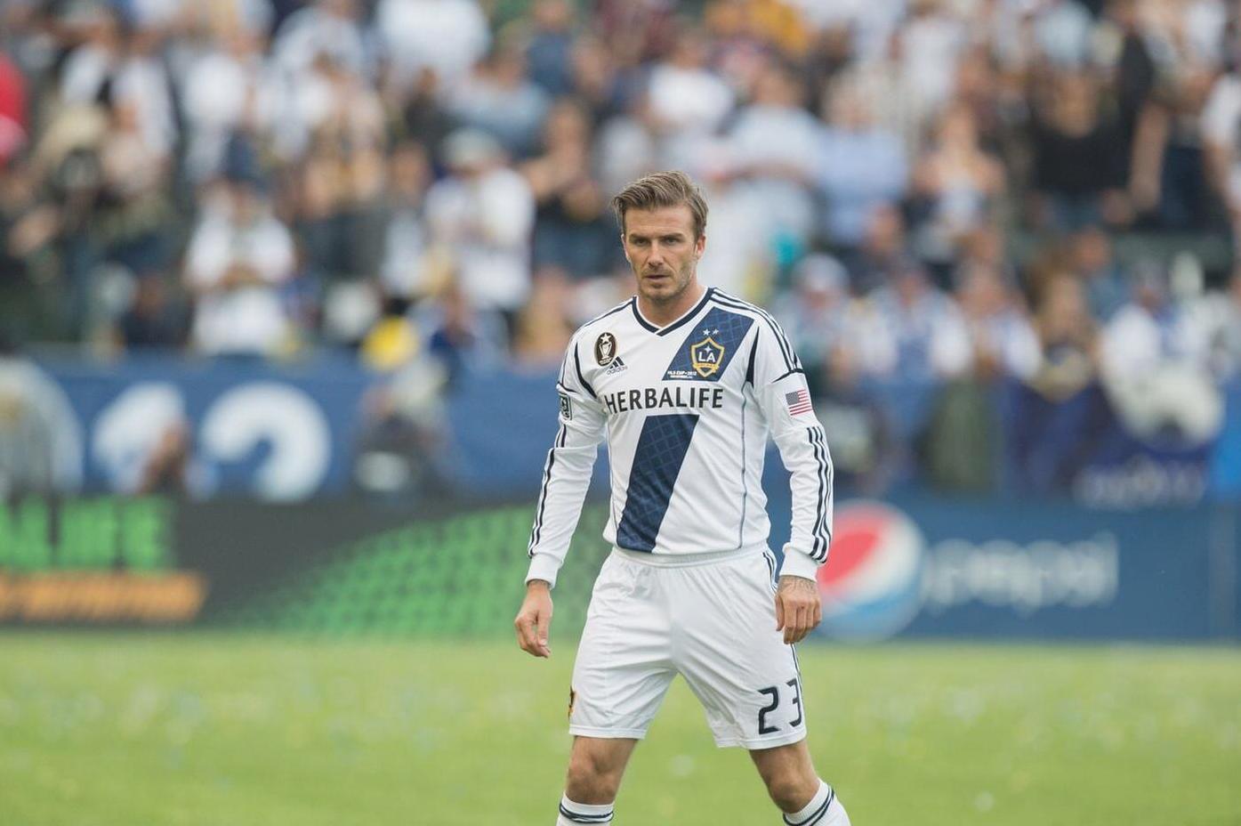 A soccer player wearing the Retro1999 LA Galaxy 2012-13 Home Shirt with number 23 stands on the field, echoing memorable moments from David Beckham’s last season.