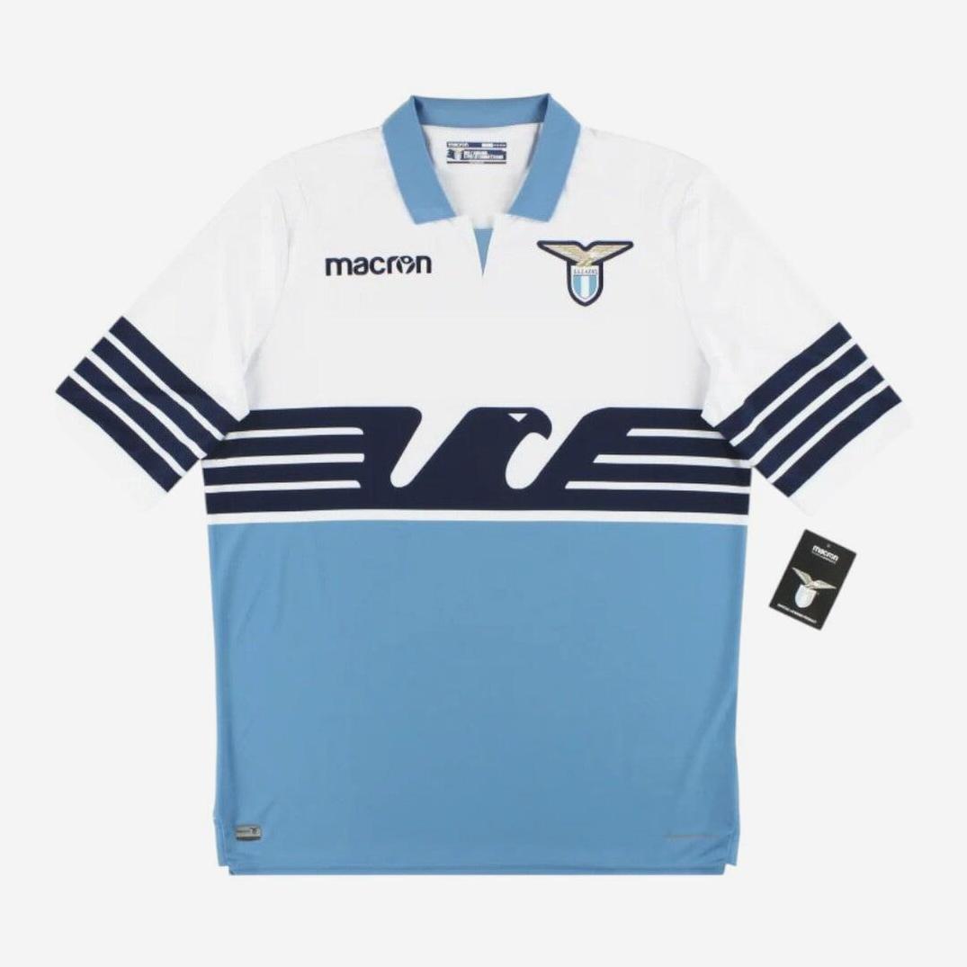 The Retro1999 Lazio 2018-19 Home Shirt features a white top, light blue bottom, bold navy eagle across the chest, navy sleeve stripes, and showcases both the Macron logo and S.S. Lazio crest on the front.