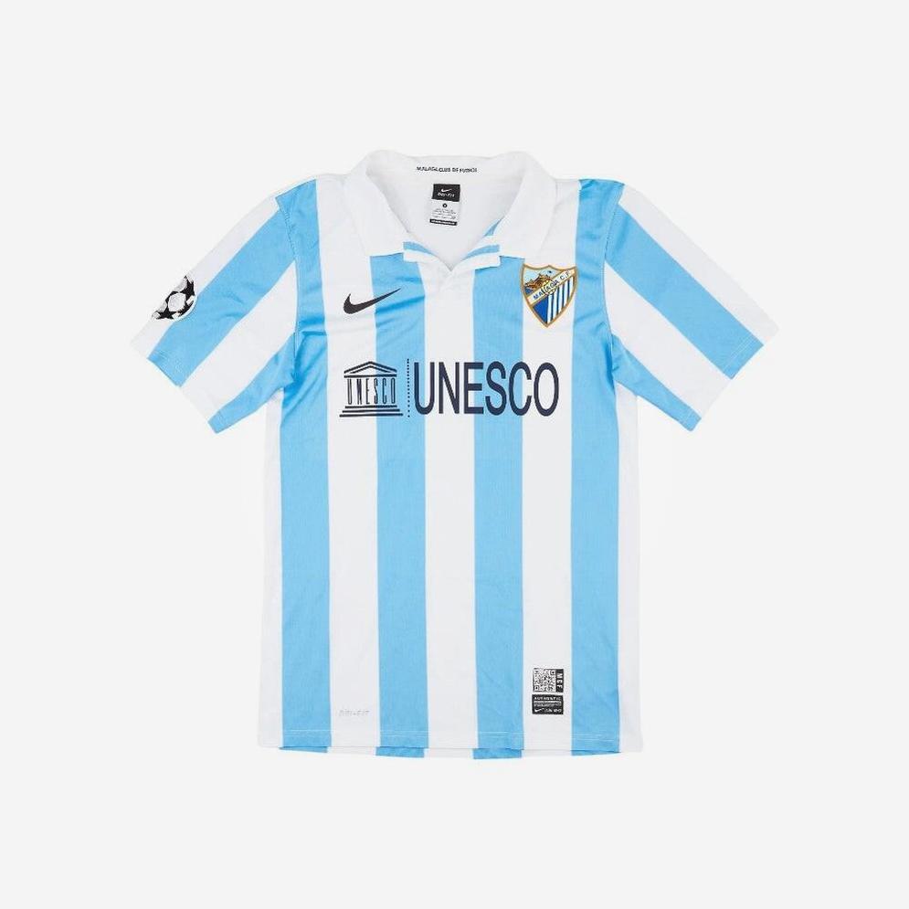 A must-have for football fans, the Malaga 2012-13 Home Shirt by Retro1999 features light blue and white stripes, a collared design, Nike logo, Málaga CF crest, Champions League patch, and UNESCO sponsor chest print.