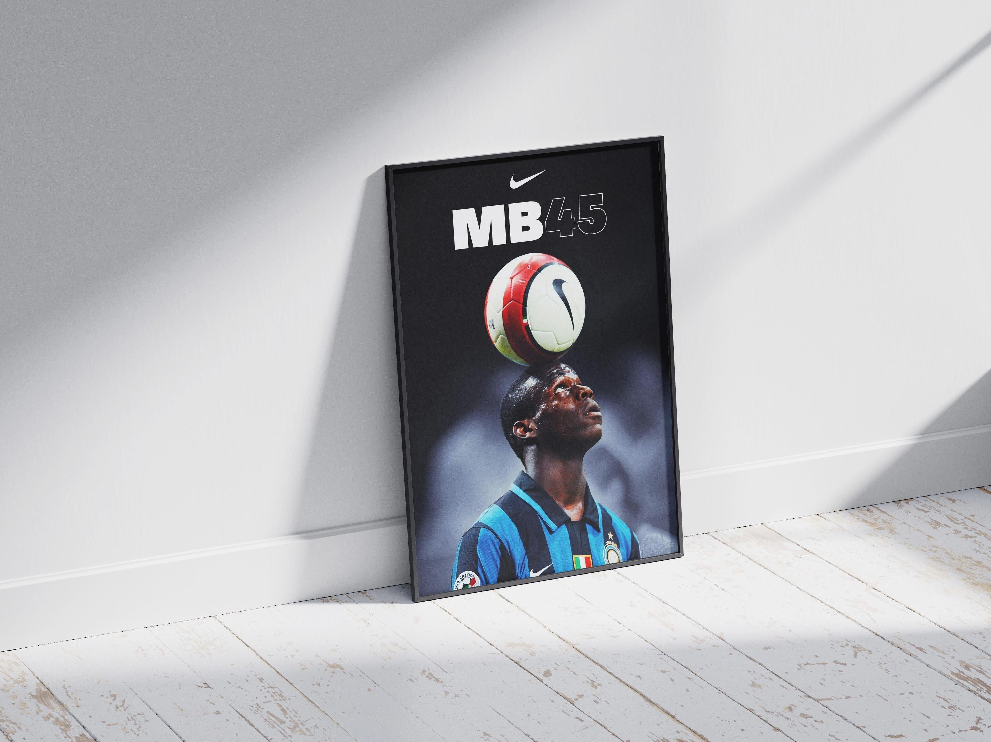 The Retro1999 Mario Balotelli Inter Milan Poster features the star in a blue and black jersey balancing a soccer ball on his head, with Nike MB45 above, leaning against a white wall as sunlight casts shadows on the wooden floor.