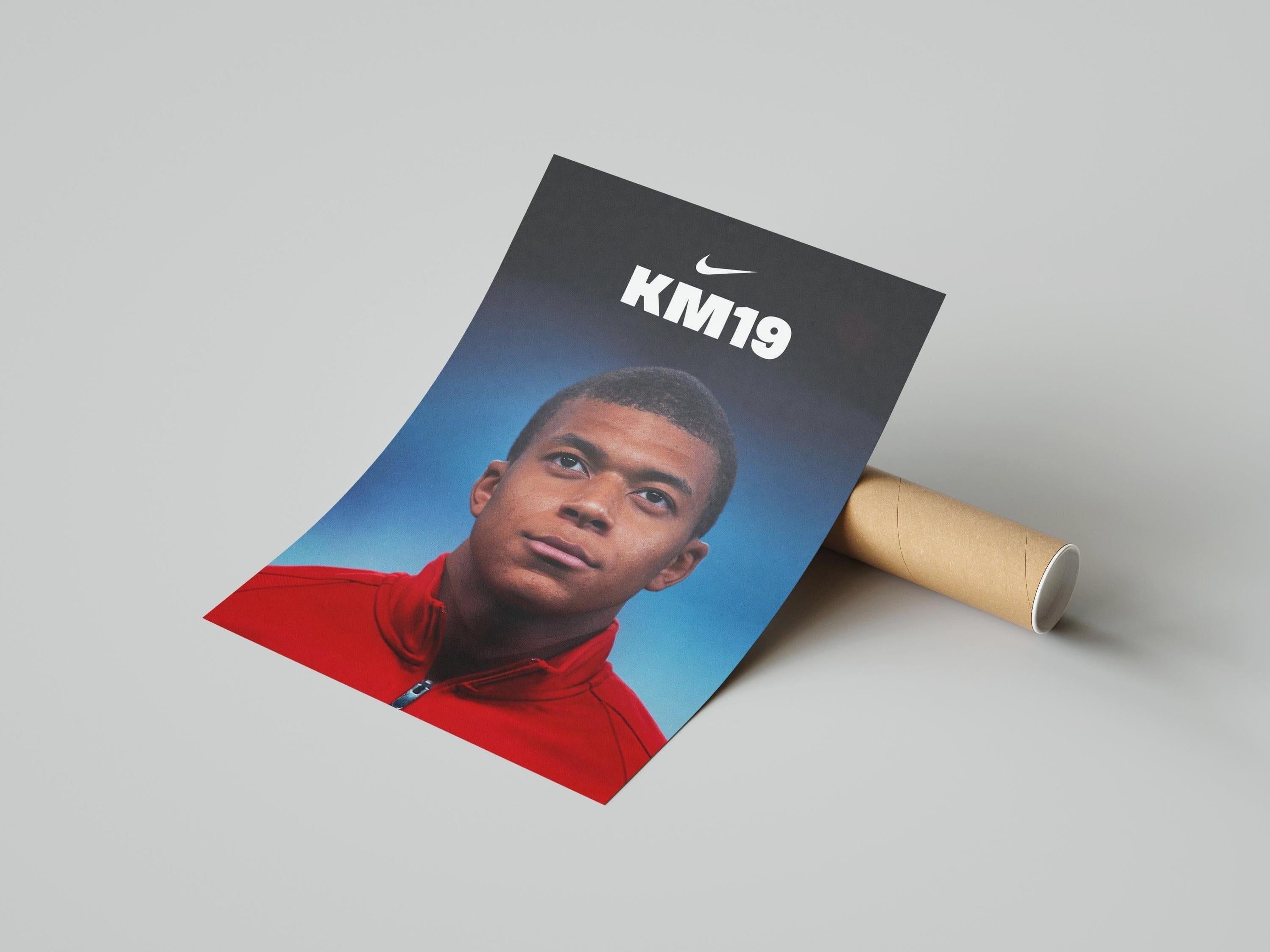 The Mbappe x AS Monaco Poster by Retro1999 shows young star Mbappe in a red jacket with KM19 and a white Nike logo above, rolled-up and resting on a light gray surface.