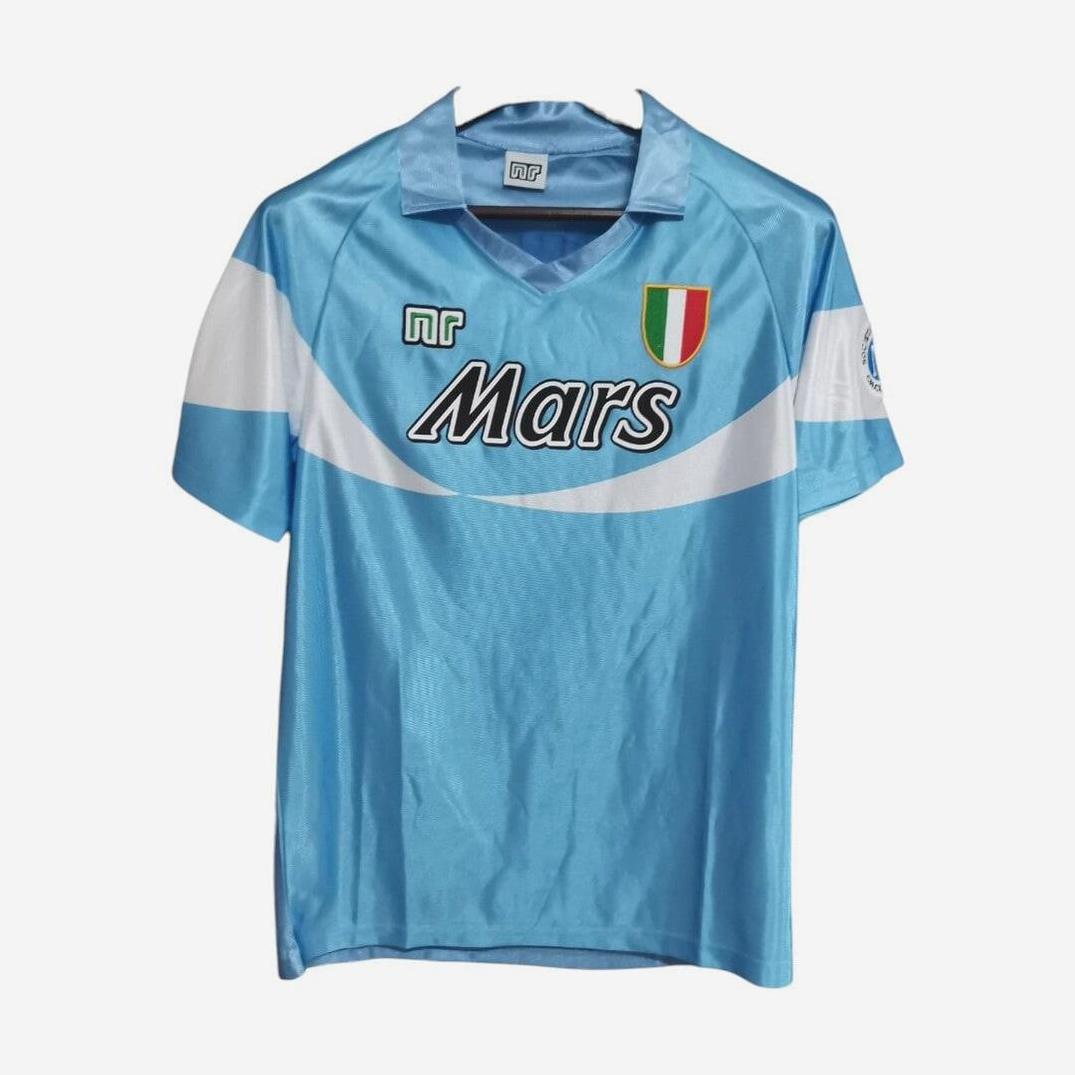 The Retro1999 Napoli 1990-91 Home Shirt in light blue features a white diagonal stripe, Mars sponsor, MR logo, green-white-red shield patch, and short sleeves—ideal for Serie A fans. Shown on a plain white background.