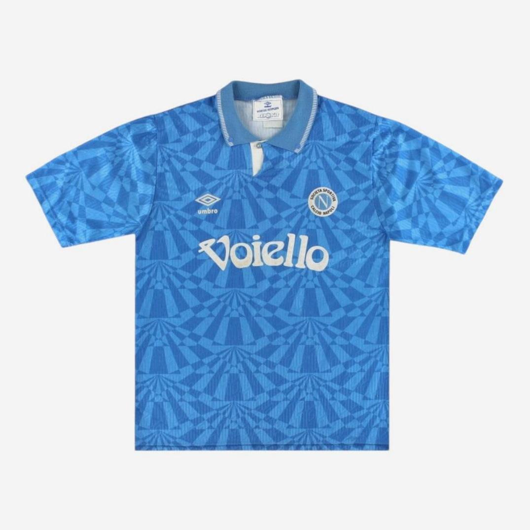The Napoli 1991-93 Home Shirt by Retro1999 features blue geometric patterns, a white Voiello sponsor logo, Umbro logo, and club badge on the chest. With a gray collar with white accents and short sleeves, its perfect for football enthusiasts.