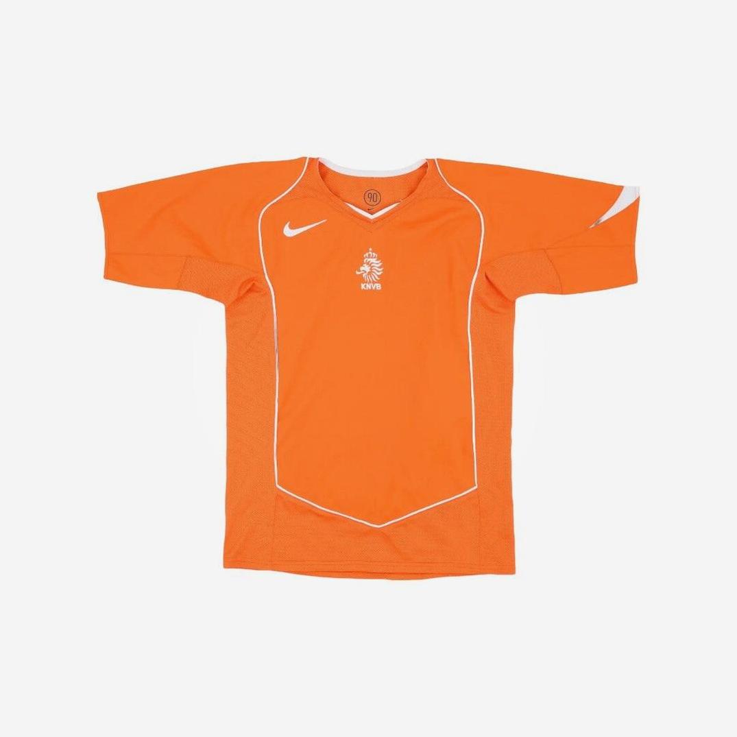 The Retro1999 Netherlands 2004 Home Shirt features an orange short-sleeve design with white piping, a Nike logo, and the KNVB lion crest—an essential retro kit for Dutch football fans, shown on a plain white background.