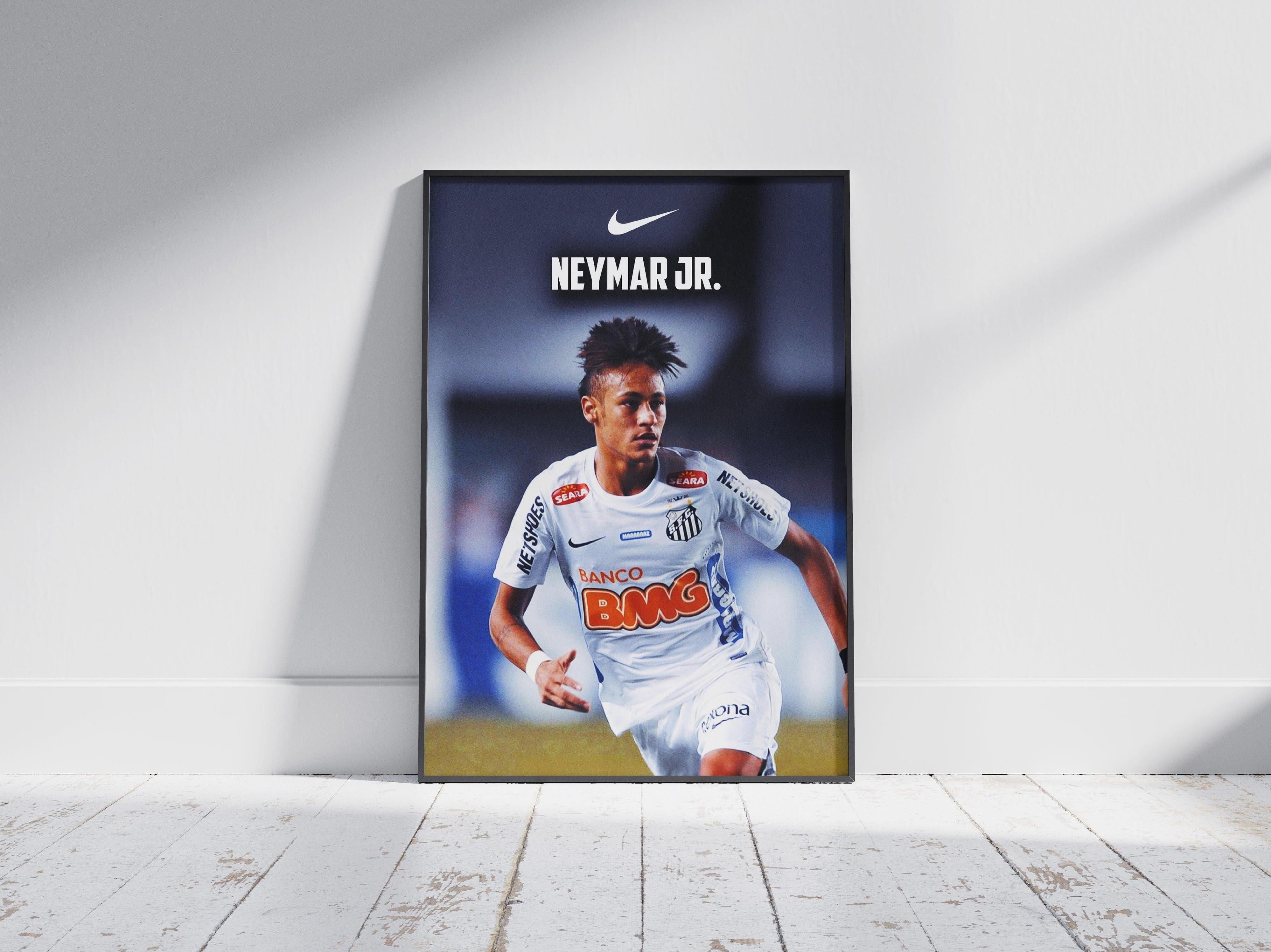 The Neymar Jr. x Santos Poster 2 by Retro1999 shows the soccer star in a white Santos FC jersey with Nike logo, celebrating Copa Libertadores 2012. Framed and displayed on a light wooden floor—ideal for football history fans.