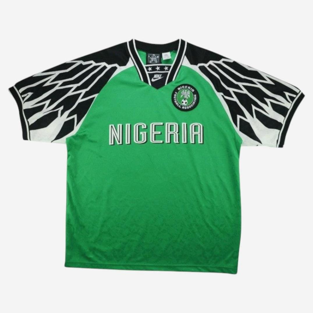The Retro1999 Nigeria 1994 Home Shirt features green fabric, bold black and white wing patterns on the shoulders, “NIGERIA” across the chest, and the national team crest—celebrating Nigerian football heritage.