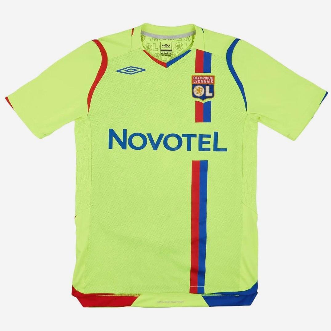 The Retro1999 Olympique Lyon 2008-09 Away Shirt features neon yellow with blue and red vertical stripes, NOVOTEL sponsor, and Umbro chest logo—a standout retro Ligue 1 classic.