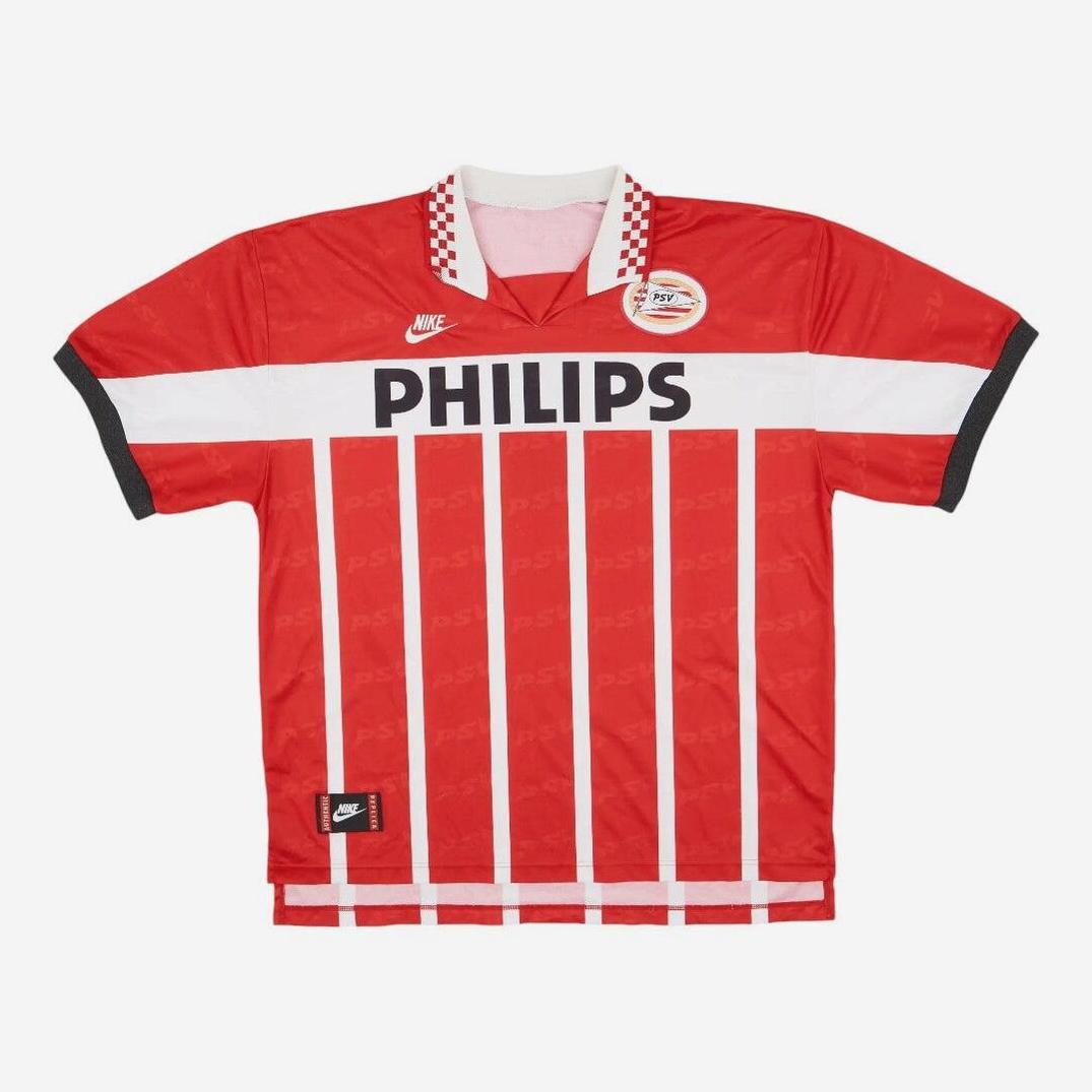 The Retro1999 PSV 1995-96 Home Shirt features iconic red and white stripes, “PHILIPS” sponsor, Nike logo, club badge, short sleeves, and a checkered collar—a standout retro football kit.
