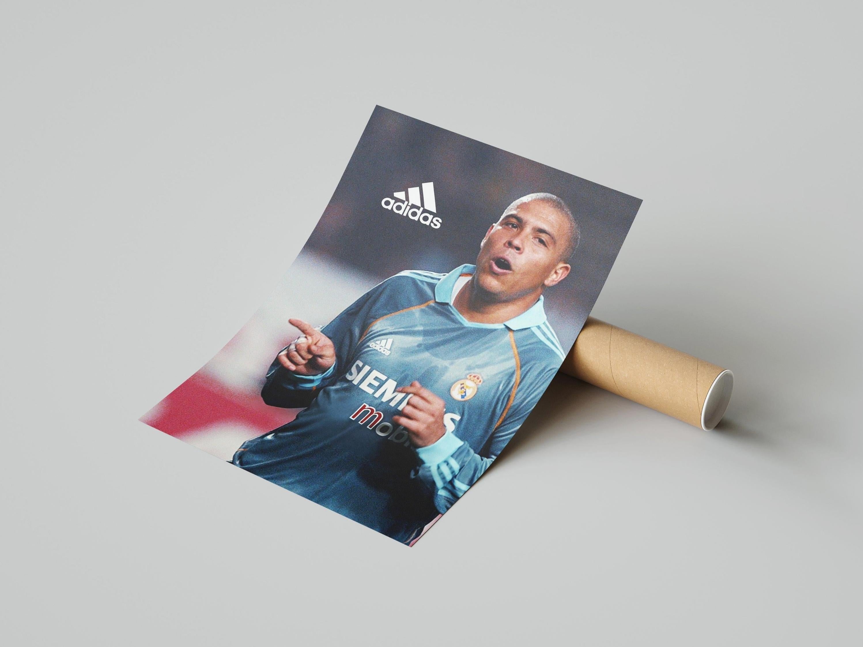 The Retro1999 R9 x Real Madrid Poster features a soccer star in a blue Siemens Mobile jersey, celebrating with the Adidas logo above. A great collectible for Spanish Primera Liga fans.