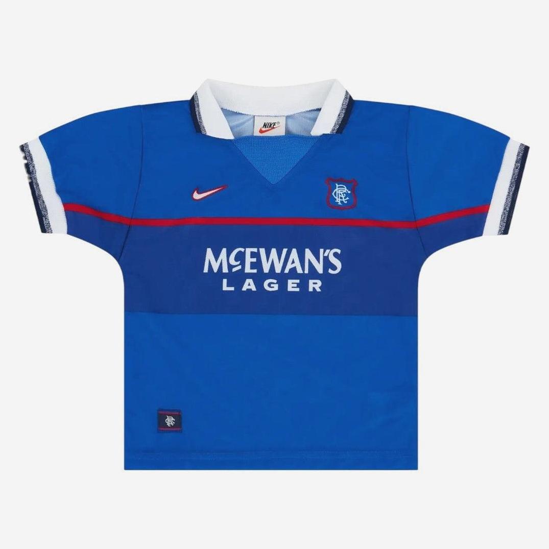 The Rangers F.C. 1997-99 Home Shirt by Retro1999 features a blue design with white collar and cuffs, club badge, Nike swoosh, and McEwans Lager sponsor. Perfect retro kit for collectors. Shirt is displayed flat on a white background.