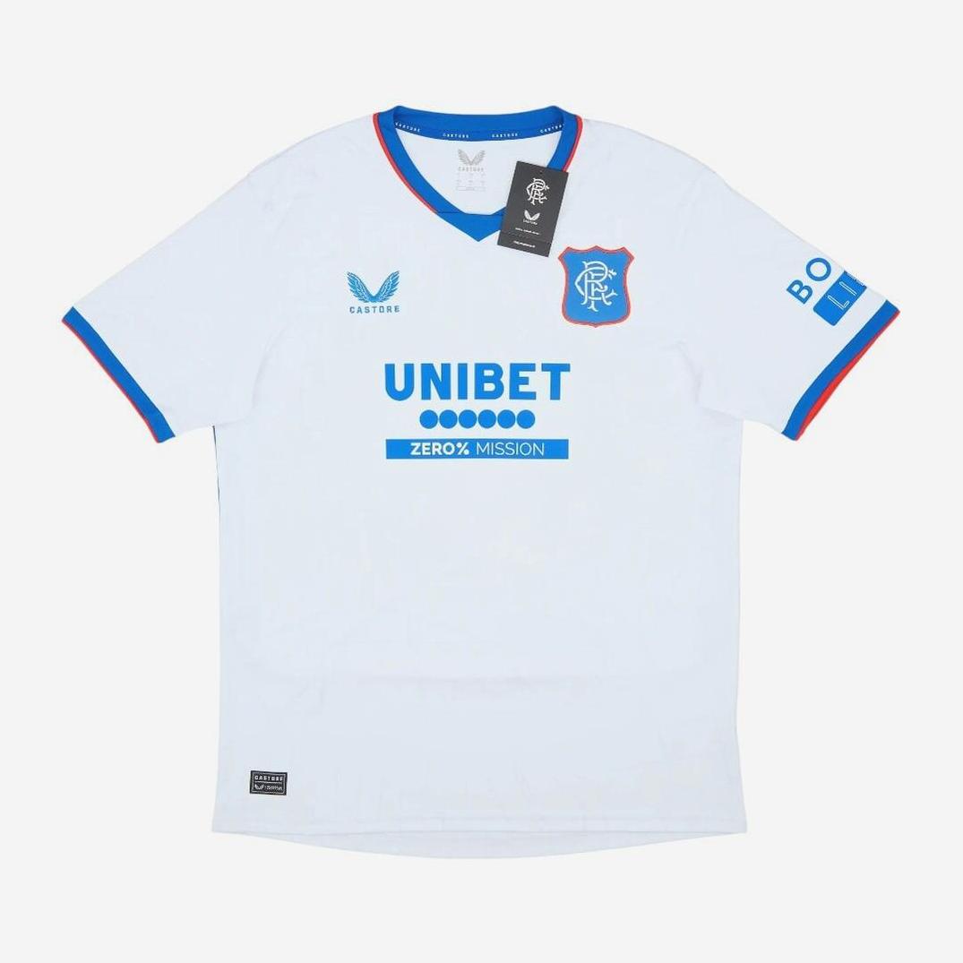 The Retro1999 Rangers F.C. 2024-25 Away Shirt is white with blue and red trim, blue sponsor logos, the team crest on the left chest, blue-edged sleeves, attached tags near the collar, and offers a comfortable fit.