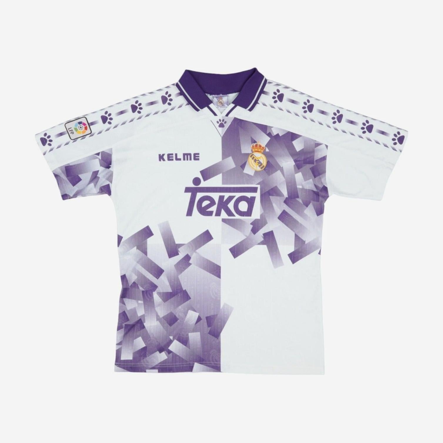 The Real Madrid 1996-97 Third Shirt by Retro1999 features a white and purple geometric design, club crest, Kelme and Teka logos, plus paw prints on shoulders and sleeves—retro style inspired by the classic La Liga season.