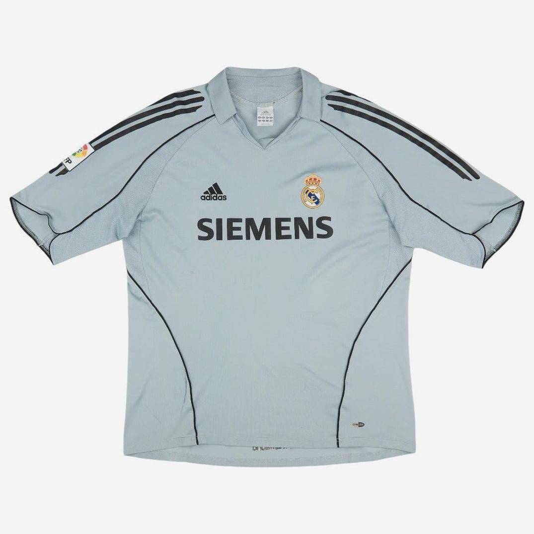 The Retro1999 Real Madrid 2005-06 Third Shirt features a light grey design with black shoulder stripes, Adidas logo, club crest, and SIEMENS sponsor—a classic retro choice for dedicated fans.