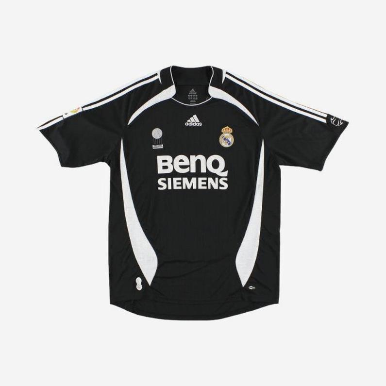 The Real Madrid 2006-07 Away Shirt by Retro1999 features a black design with white accents, Adidas logo, BenQ Siemens sponsor, club badge, and shoulder stripes—capturing La Liga title memories. Displayed flat on a white background.